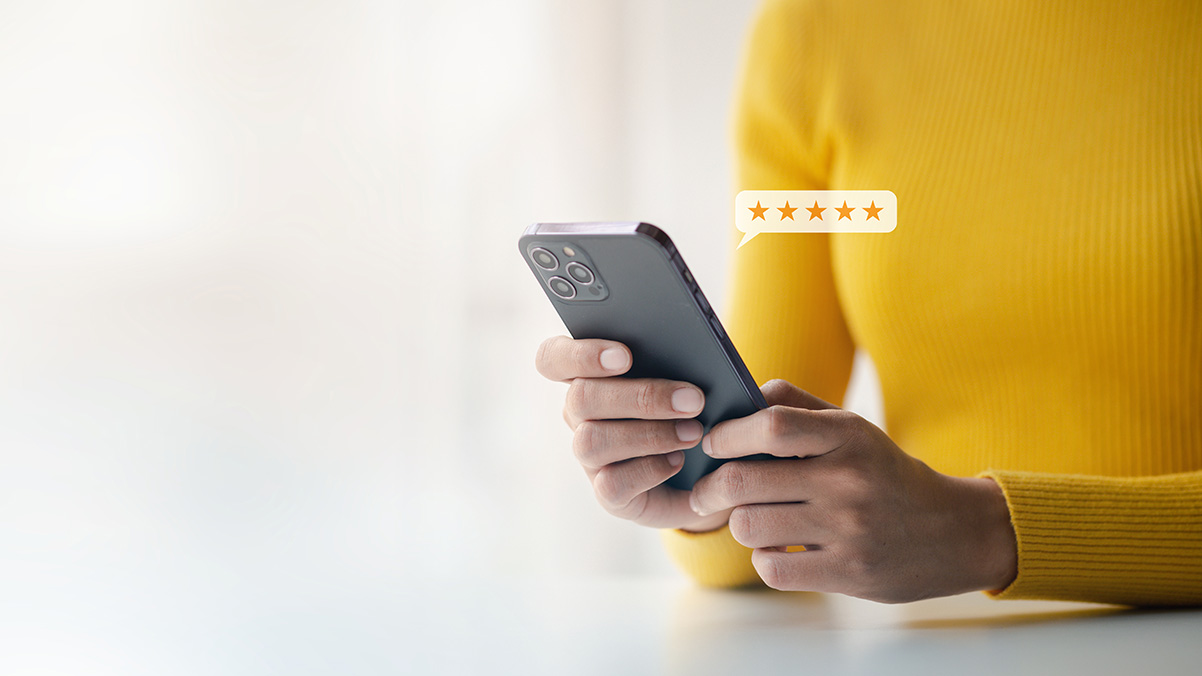 The image shows a person holding a smartphone with a yellow background and a star icon on the screen, suggesting customer satisfaction or evaluation.