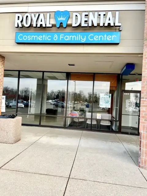 The image shows a sign for  Royal Dental Cosmetic   Family Center  outside a building with a blue sky background.