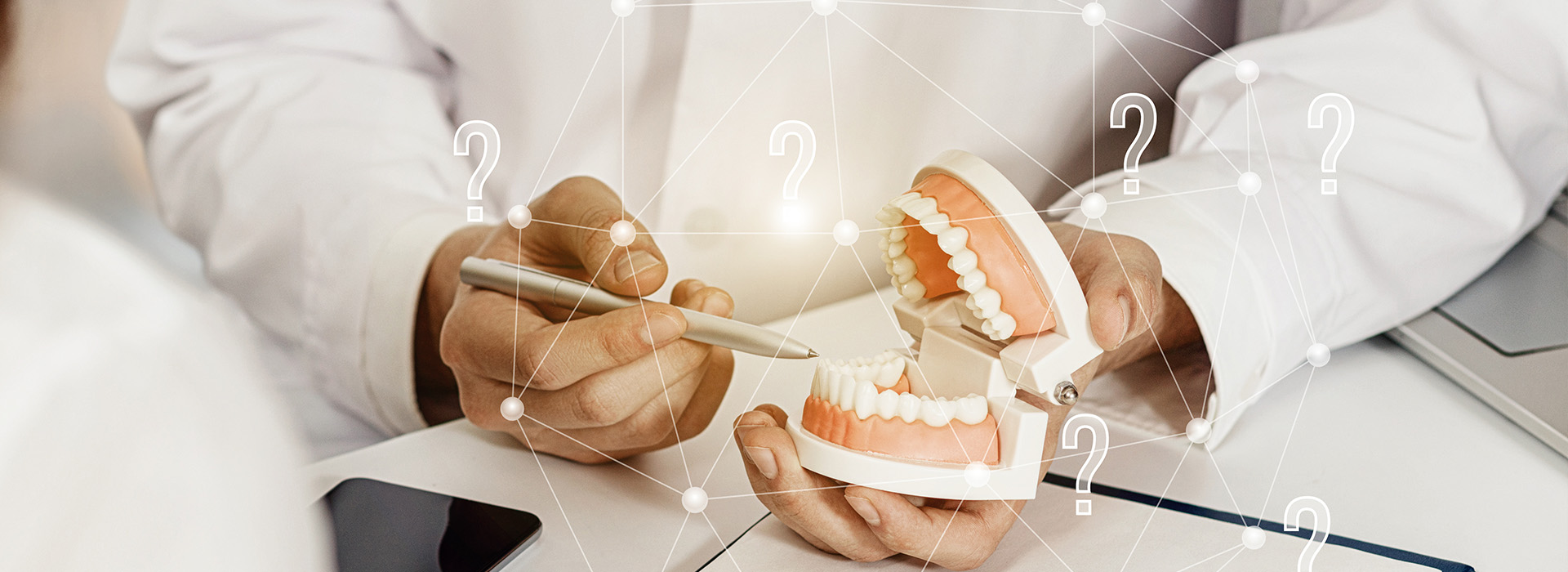 A photograph of a person s hands holding a tooth model while sitting at a table with dental equipment, surrounded by digital icons and text, likely for educational or promotional purposes.