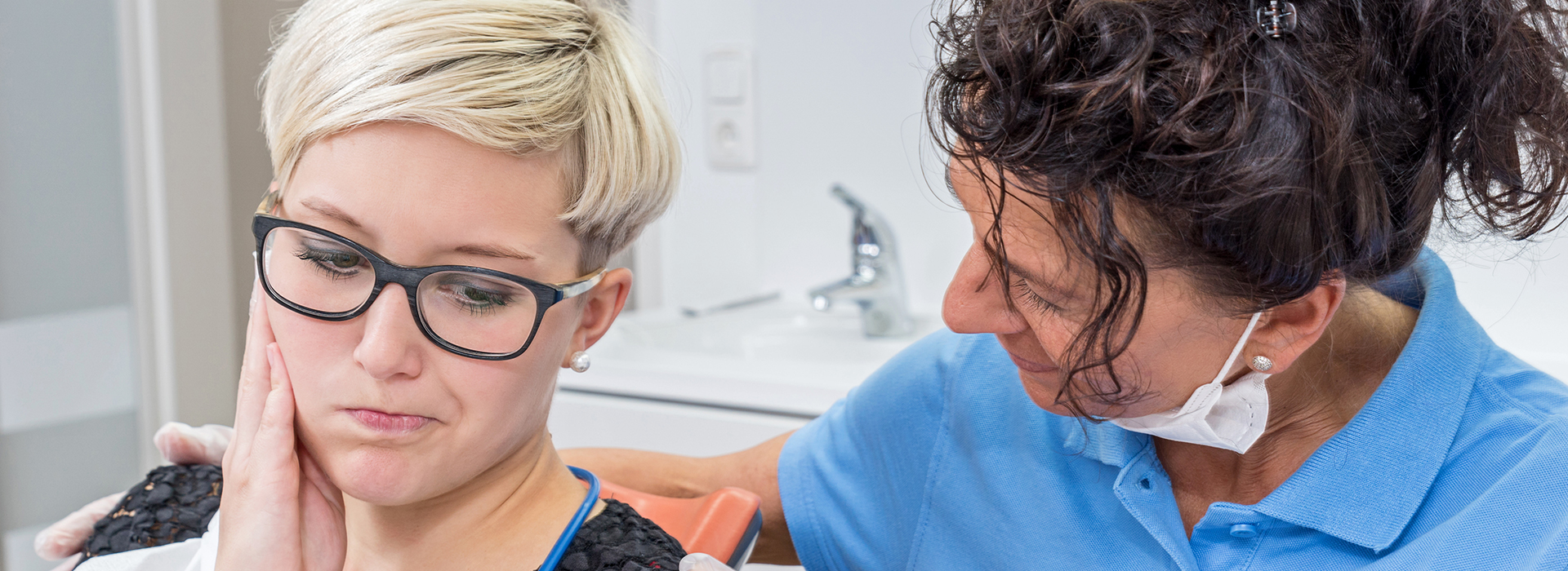 A dentist attends to a patient in a dental office setting.