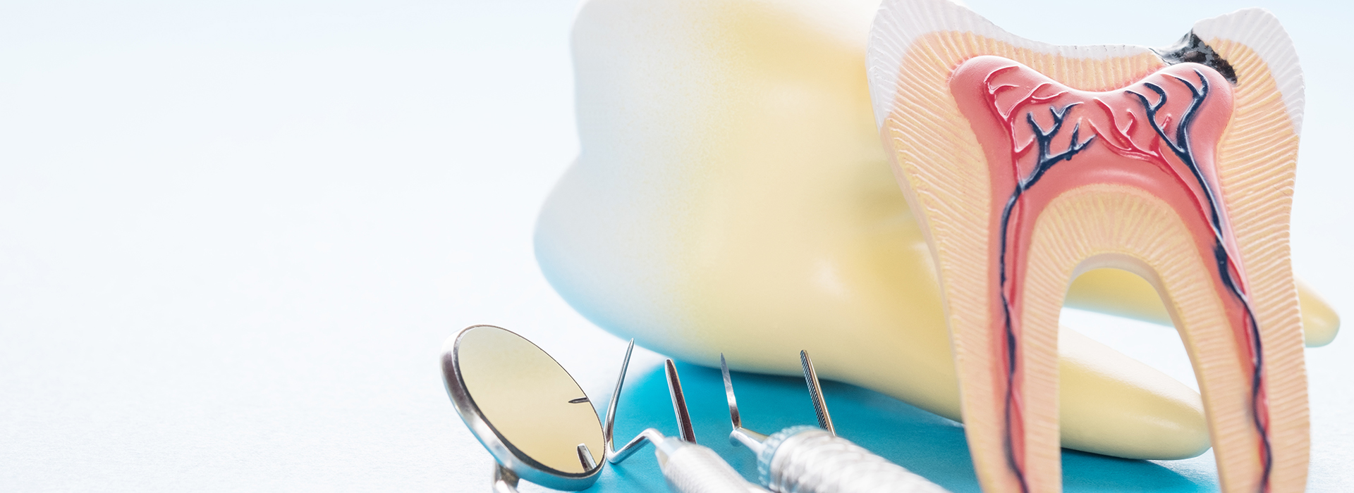The image shows a pair of dentures with a playful design featuring a cartoonish mouth and teeth, set against a blue background with a watermark or logo partially visible on the upper left side.