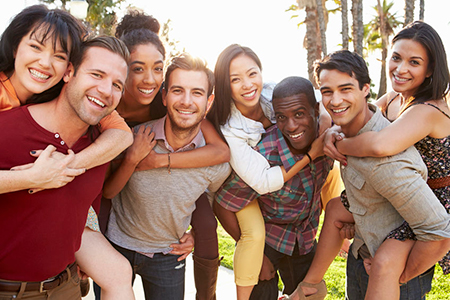 A group of people posing together for a photo outdoors, smiling and enjoying each other s company.